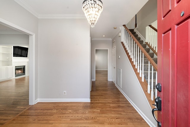 entryway featuring crown molding, a notable chandelier, and dark hardwood / wood-style flooring