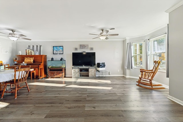 living room with ornamental molding, dark wood-type flooring, and ceiling fan