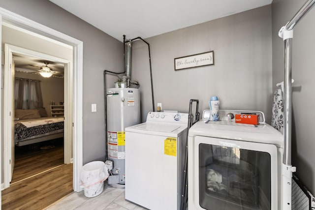 laundry room featuring ceiling fan, independent washer and dryer, light wood-type flooring, and gas water heater