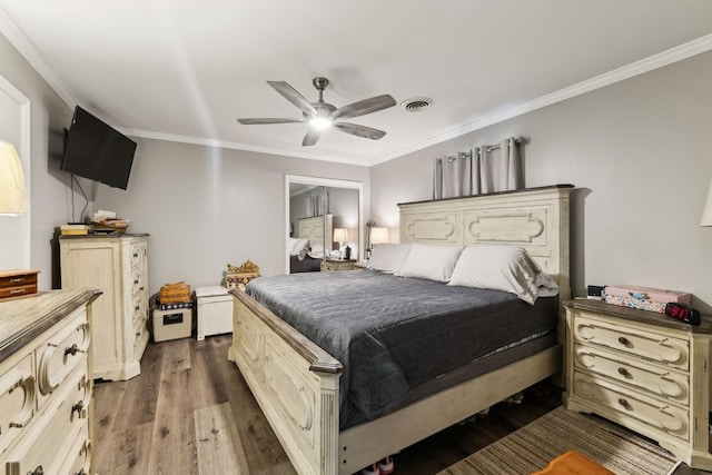 bedroom with crown molding, dark hardwood / wood-style floors, and ceiling fan