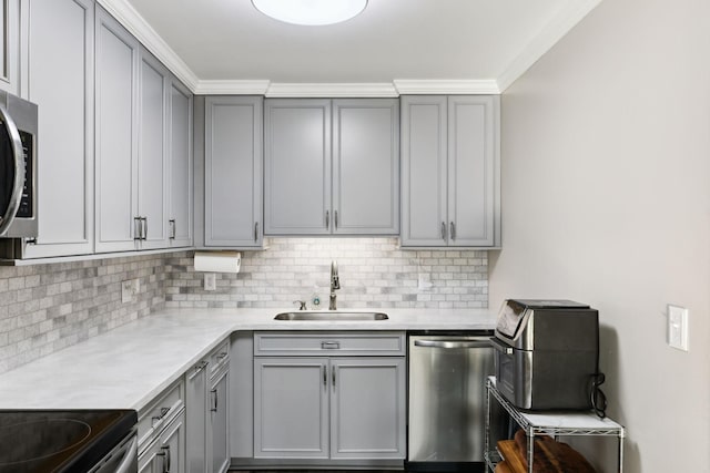 kitchen with gray cabinets, tasteful backsplash, sink, stainless steel appliances, and crown molding