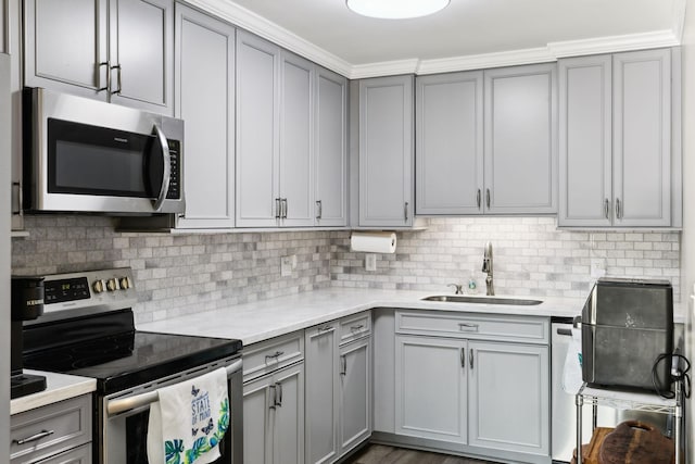 kitchen featuring appliances with stainless steel finishes, sink, decorative backsplash, and gray cabinetry