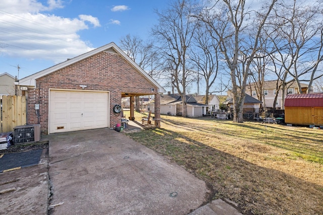 exterior space with a storage shed, a yard, central AC unit, and a garage