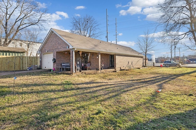 back of house with a garage and a lawn