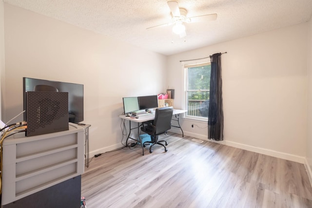 office space with ceiling fan, a textured ceiling, and light hardwood / wood-style flooring