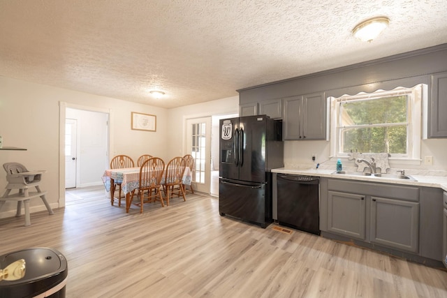 kitchen with gray cabinets, sink, light hardwood / wood-style flooring, and black appliances