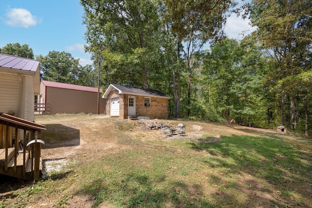 view of yard with a garage and an outbuilding