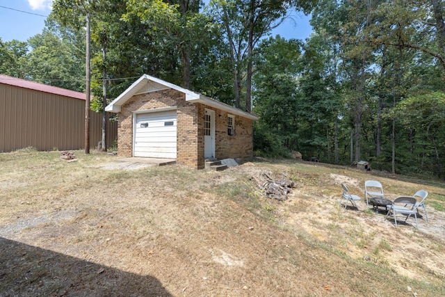 view of yard featuring a garage and an outbuilding