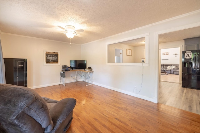 living room with wood-type flooring, crown molding, ceiling fan, and a textured ceiling