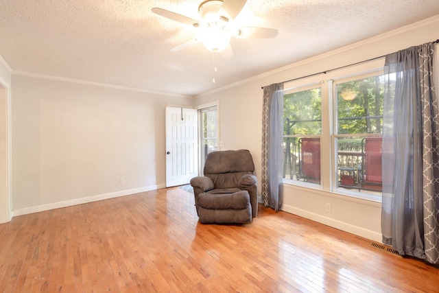 sitting room featuring crown molding, ceiling fan, a textured ceiling, and light wood-type flooring