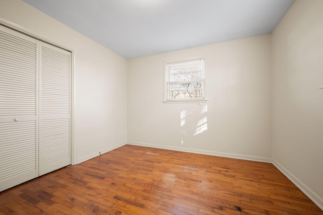 unfurnished bedroom with hardwood / wood-style flooring and a closet