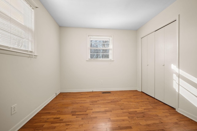 unfurnished bedroom featuring a closet and light hardwood / wood-style flooring