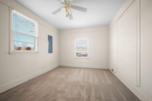 carpeted spare room with ceiling fan and electric panel