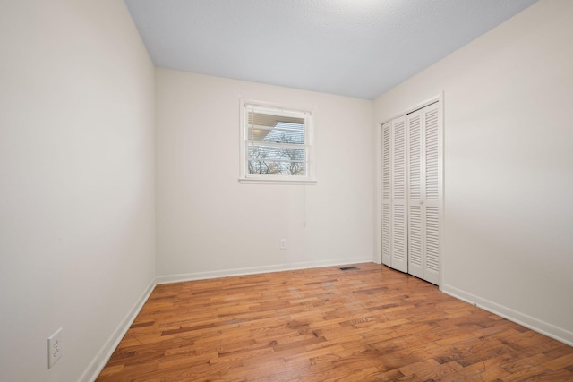 unfurnished bedroom with light hardwood / wood-style floors and a closet