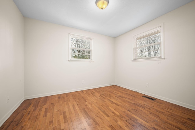 unfurnished room with a healthy amount of sunlight and wood-type flooring