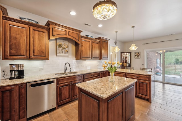 kitchen with decorative light fixtures, dishwasher, sink, decorative backsplash, and a center island