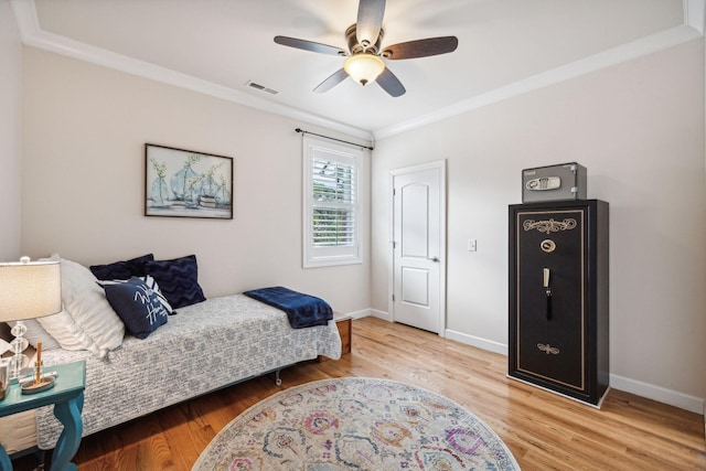 bedroom with crown molding, ceiling fan, and wood-type flooring