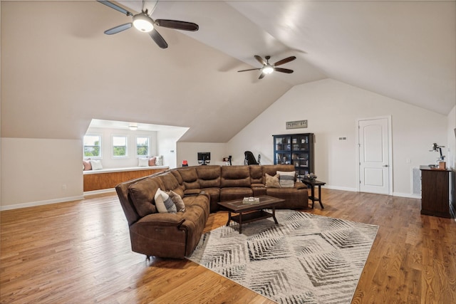 living room with light hardwood / wood-style flooring, ceiling fan, and vaulted ceiling