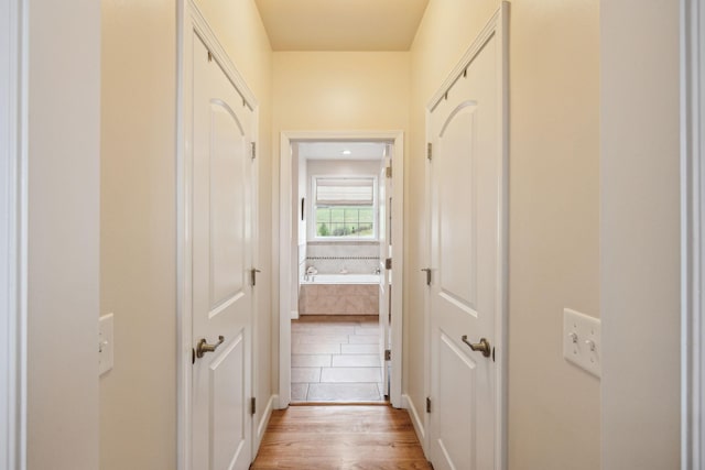 hallway with light hardwood / wood-style floors