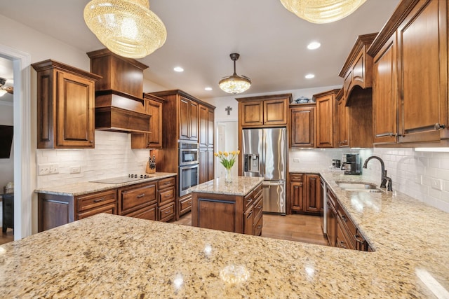 kitchen with appliances with stainless steel finishes, pendant lighting, sink, decorative backsplash, and light stone countertops