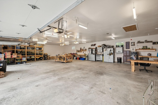 garage featuring white refrigerator, a garage door opener, a workshop area, and stainless steel refrigerator