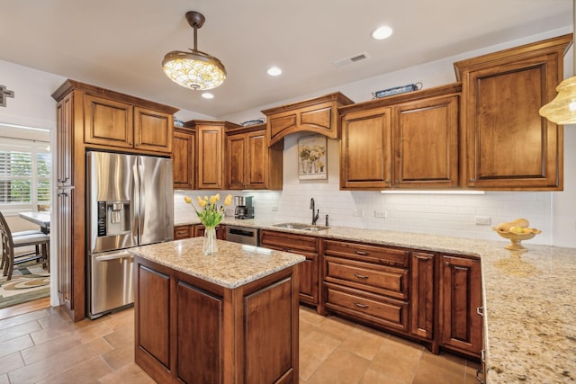 kitchen with pendant lighting, light stone countertops, decorative backsplash, and stainless steel appliances