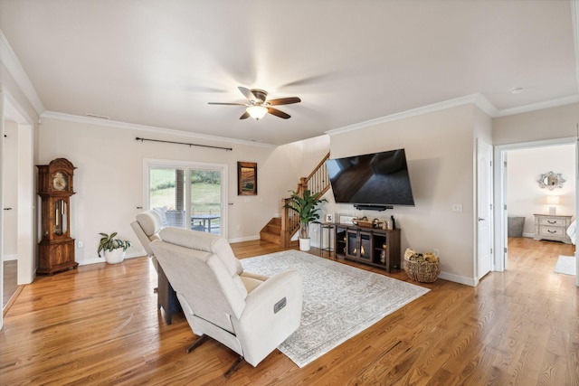 living room with ceiling fan, ornamental molding, and hardwood / wood-style floors