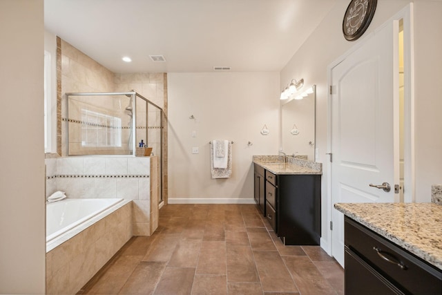 bathroom featuring vanity and independent shower and bath