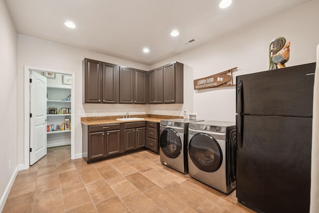 clothes washing area featuring sink and washing machine and clothes dryer