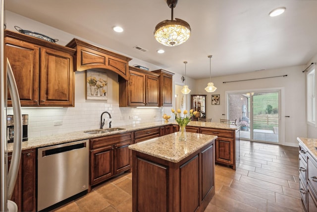 kitchen with a kitchen island, pendant lighting, dishwasher, sink, and kitchen peninsula