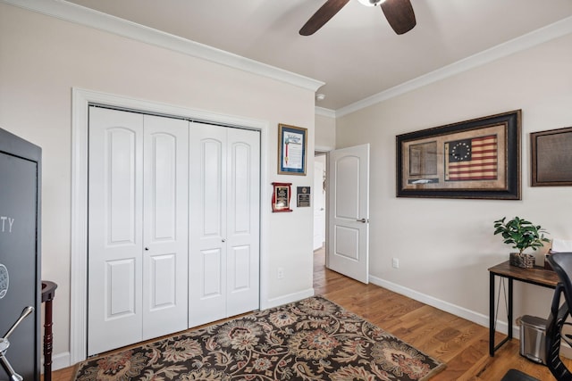 bedroom featuring wood-type flooring, ornamental molding, a closet, and ceiling fan