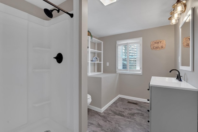 bathroom featuring walk in shower, vanity, and toilet