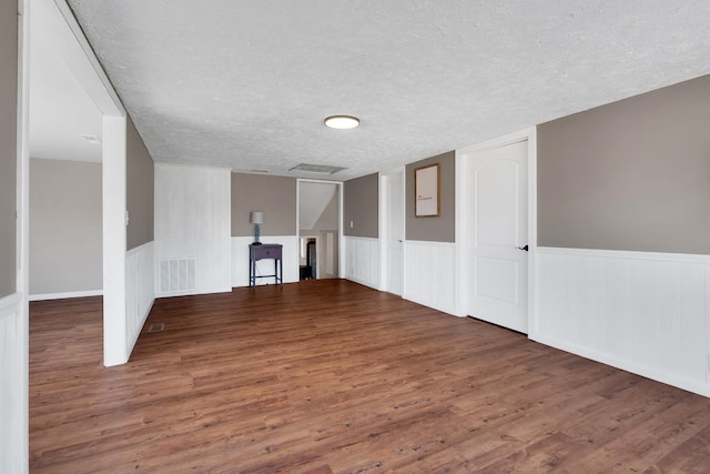 spare room with dark hardwood / wood-style floors and a textured ceiling