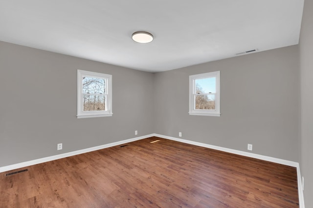 spare room with wood-type flooring and a wealth of natural light