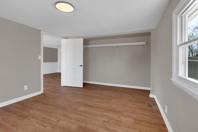 unfurnished bedroom featuring hardwood / wood-style floors and a closet