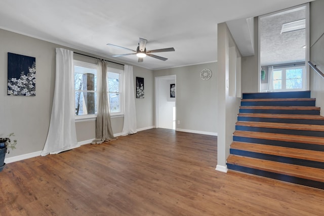 interior space with hardwood / wood-style flooring, ornamental molding, and ceiling fan