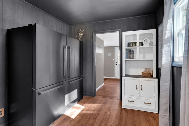 kitchen featuring ornamental molding, stainless steel fridge, hardwood / wood-style floors, and white cabinets