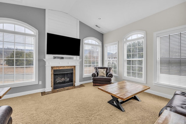 carpeted living room with lofted ceiling and a wealth of natural light