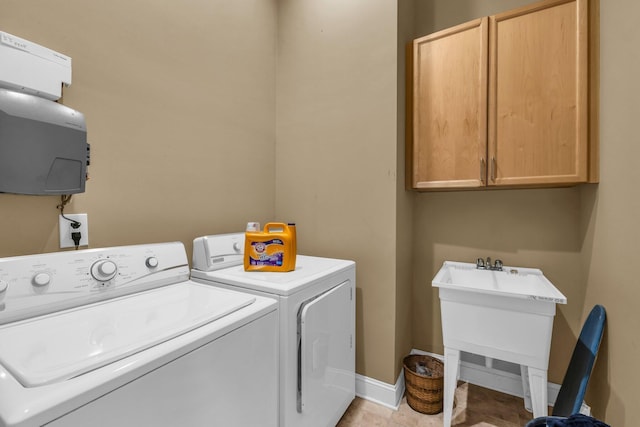 clothes washing area featuring cabinets and separate washer and dryer