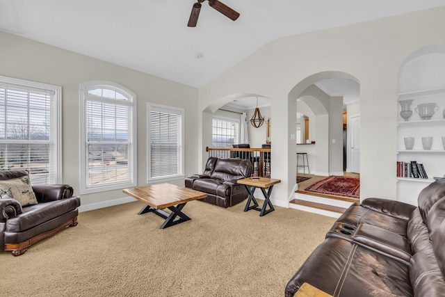 living room with ceiling fan with notable chandelier, lofted ceiling, and carpet floors