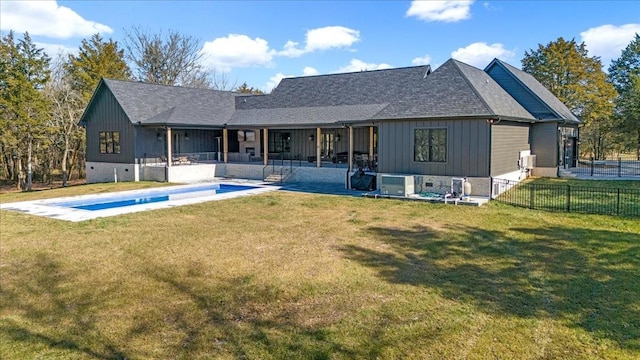 rear view of property with a fenced in pool, a lawn, and a patio