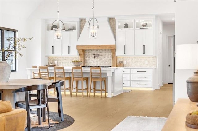 kitchen featuring pendant lighting, custom exhaust hood, and white cabinets