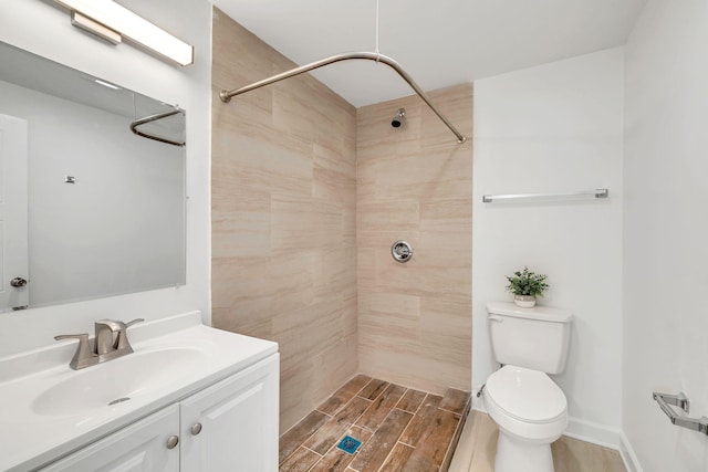 bathroom featuring vanity, tiled shower, and toilet