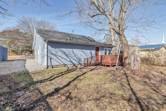 rear view of house featuring a lawn and a deck