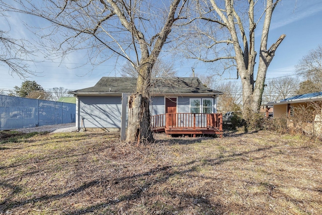 rear view of property featuring a yard and a deck