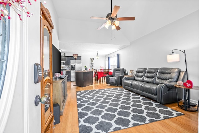 living room featuring lofted ceiling, hardwood / wood-style floors, and ceiling fan