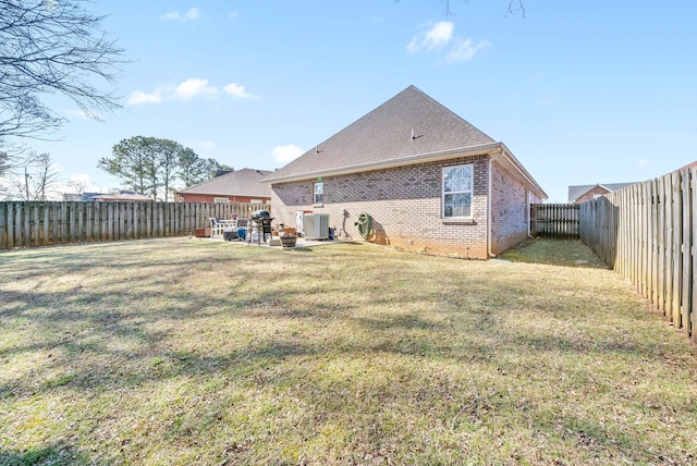 rear view of house with a yard and central air condition unit