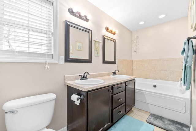 bathroom featuring vanity, toilet, a bathing tub, and tile patterned flooring