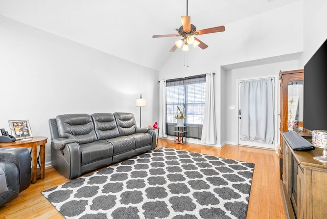 living room with ceiling fan, high vaulted ceiling, and light wood-type flooring