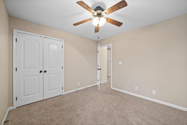 unfurnished bedroom featuring a ceiling fan, carpet, baseboards, and a closet